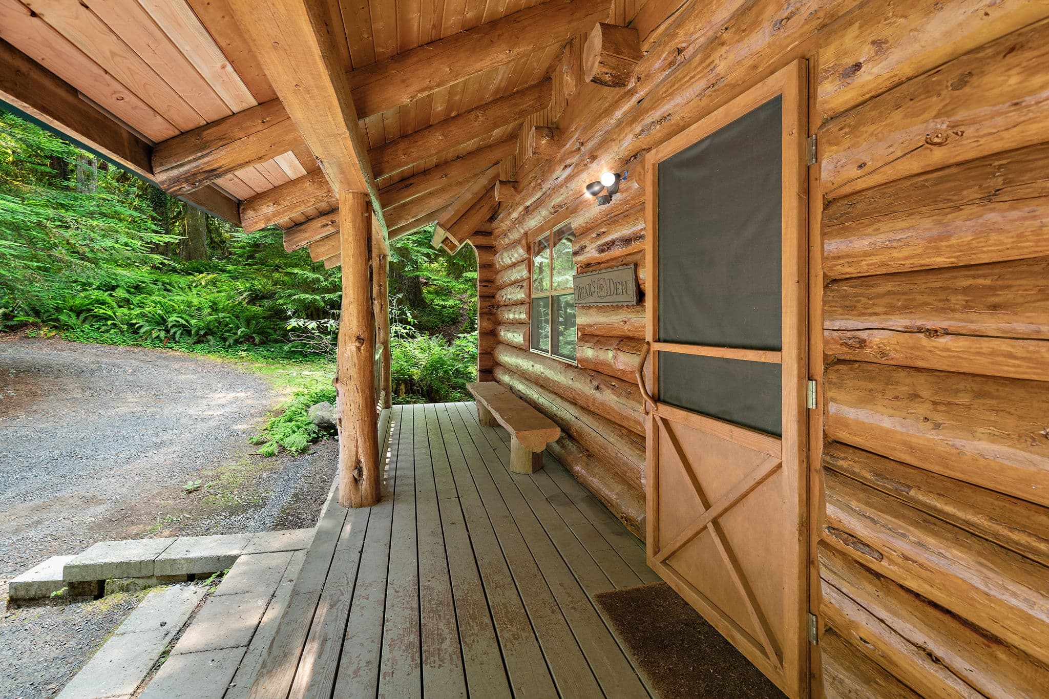 Covered front porch with a bench by the door.