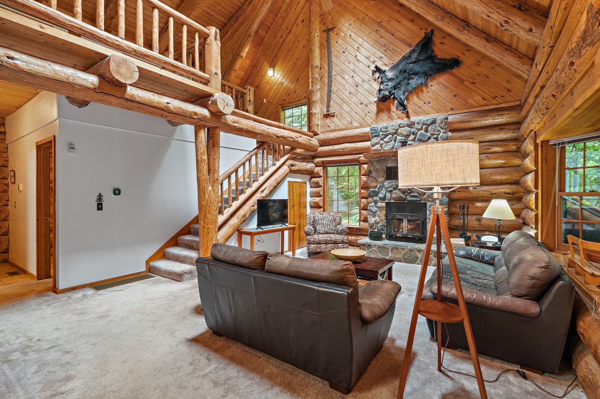 Open living room beneath the loft, with the staircase upstairs.