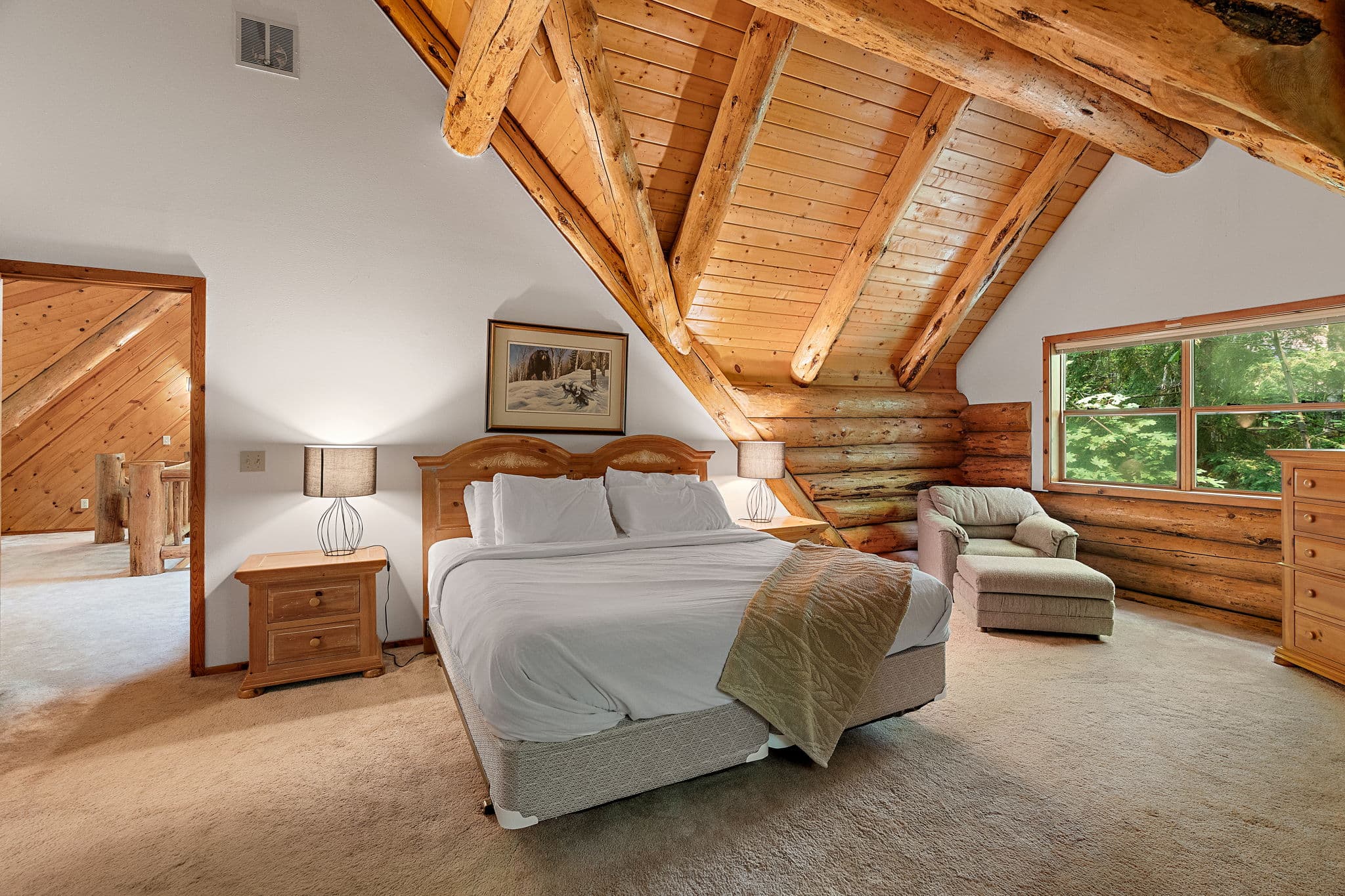 Master bedroom with a reading chair by the window.