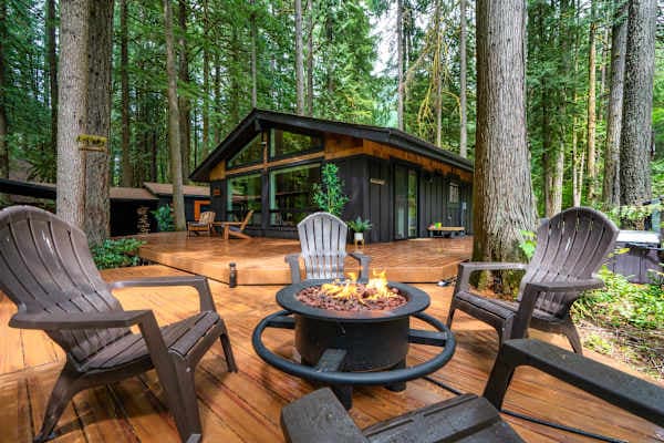 Deck fire pit surrounded by trees.