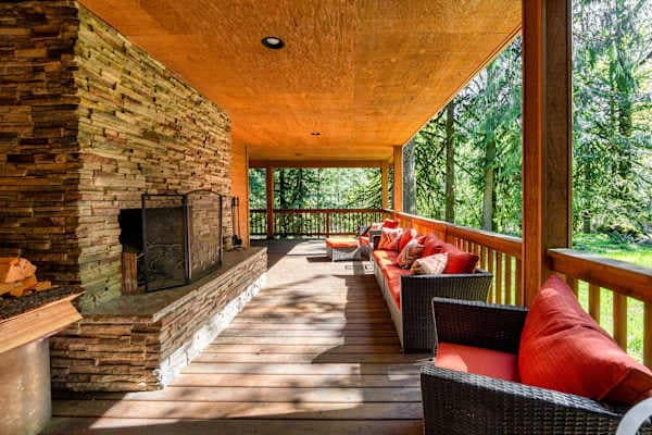 The covered deck is a second living room, with its own stone fireplace.