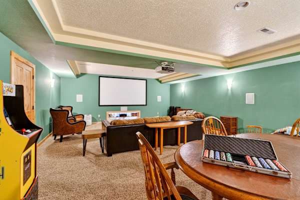 Movie nights on the projector wall; arcade cabinet and poker set ready too.